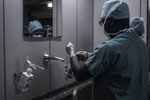 A doctor scrubs up before surgery to protect his patient.